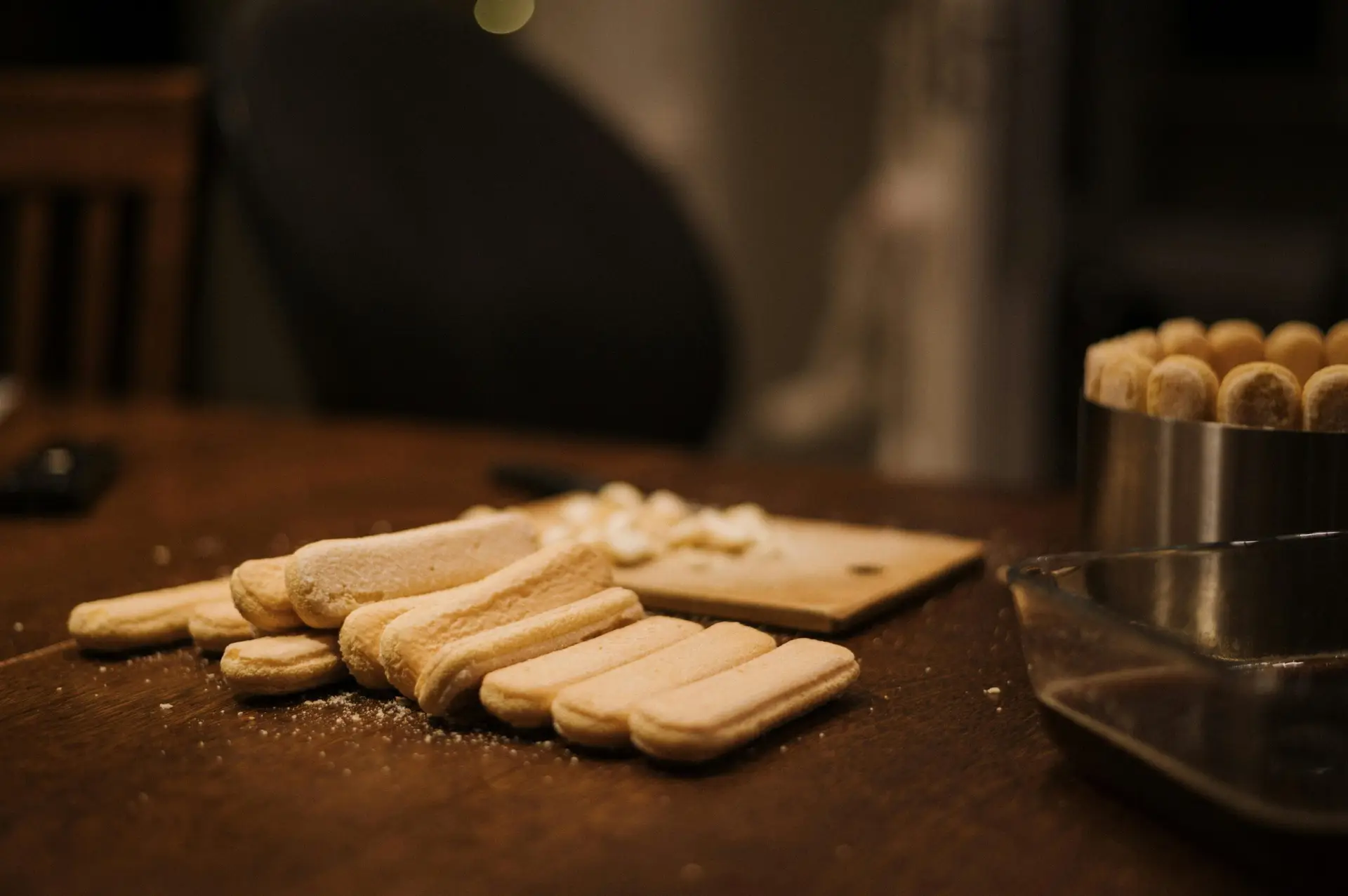 Ladyfingers laid out for a homemade dessert preparation in a cozy kitchen setting.